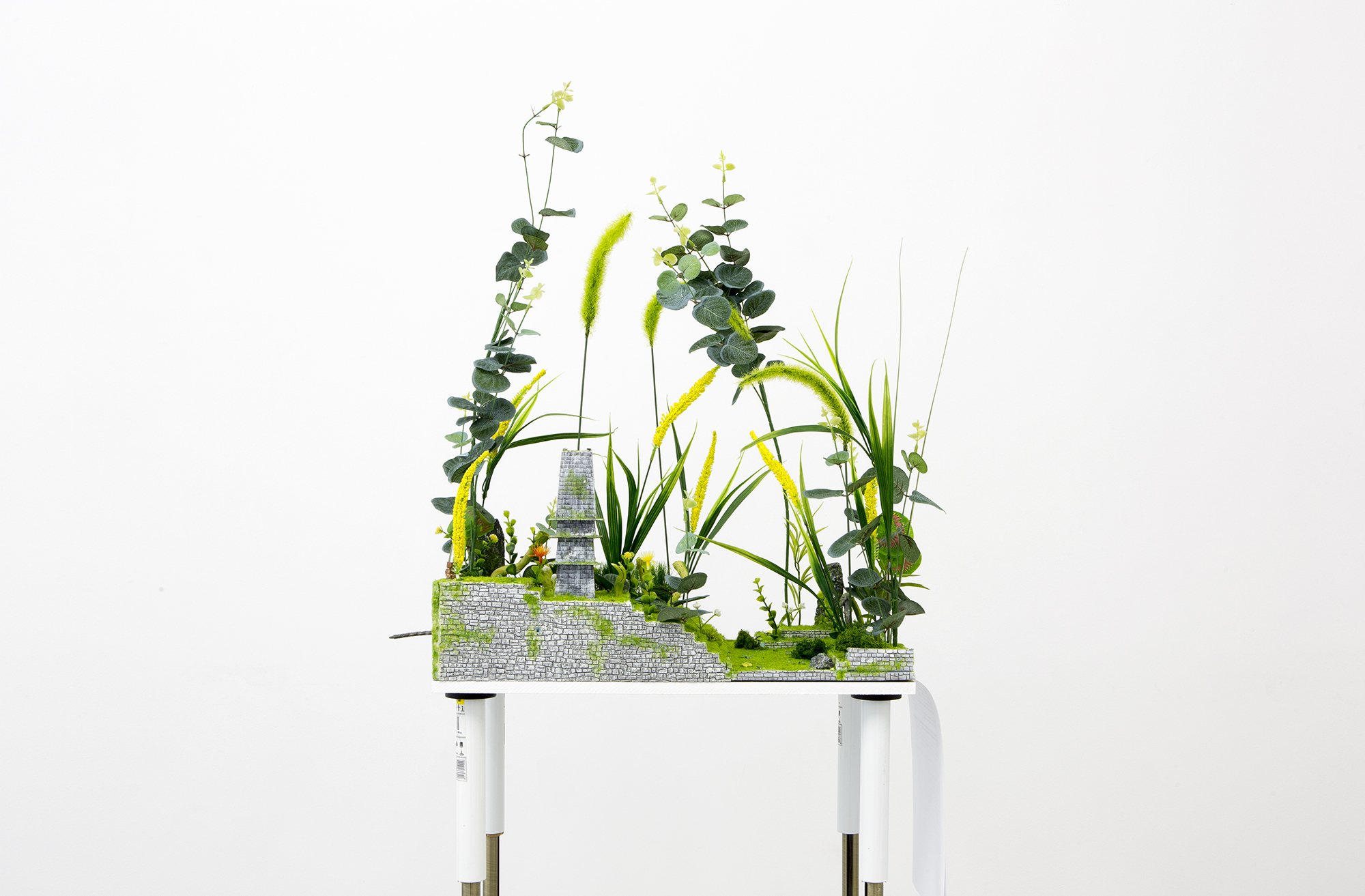 Veit Laurent Kurz, “Fettgrässli (Pleurozia)”, 2013, styrofoam, glue, acrylic colour, candle gel, wood, electronic parts, metal, plaster, plastic plants and stone, 500 × 200 mm (heights variable) Courtesy the artist and Johan Berggren Gallery